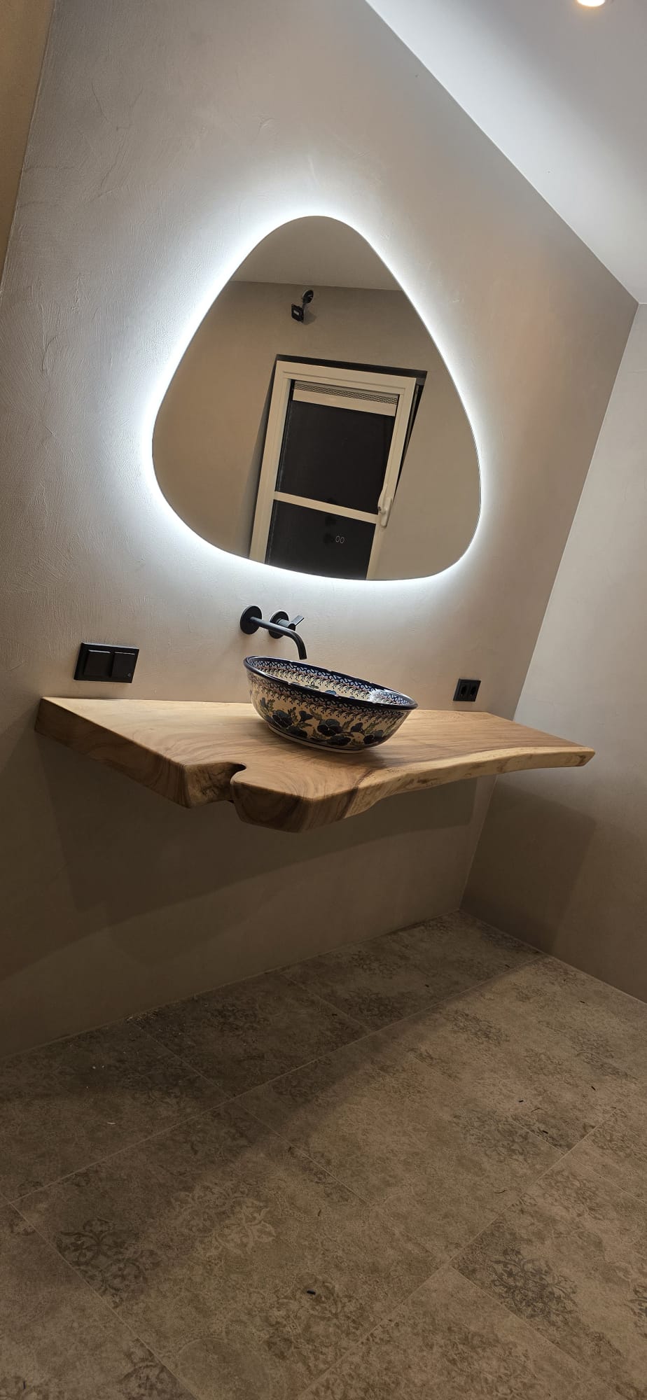 Badkamer met wanden in beton ciré en zwevend boomstamblad
